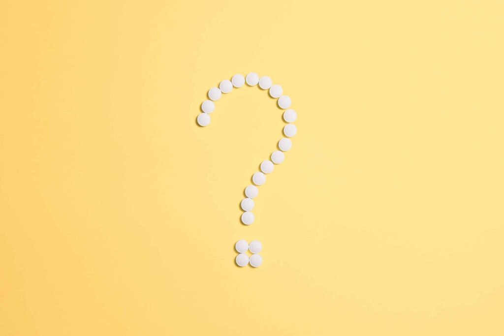 alcohol rehab covered by umr, a yellow background with pills laid in the shape of a question mark